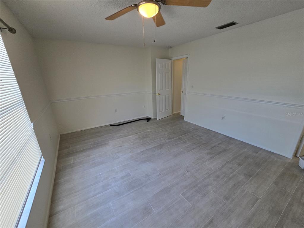 11127 Peppertree Lane Port Richey, FL 34668 - Photo 13 of 25 a view of an empty room with wooden floor