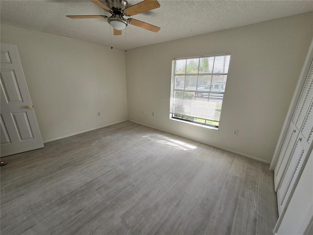 11127 Peppertree Lane Port Richey, FL 34668 - Photo 15 of 25 an empty room with a window and a ceiling fan