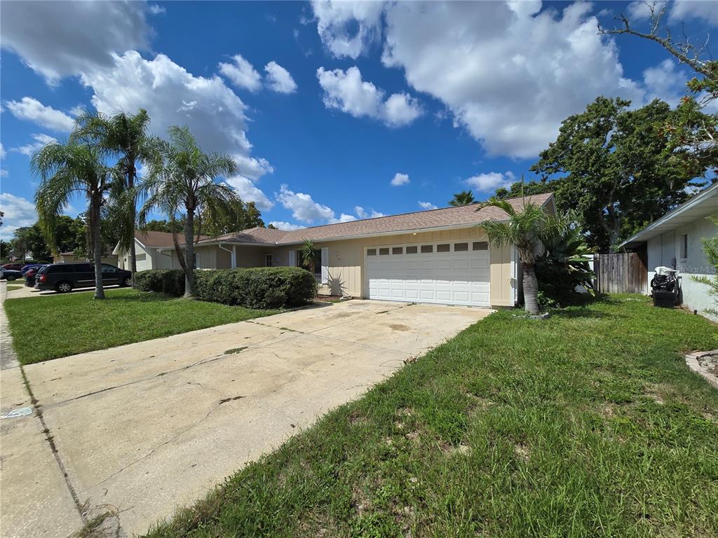 11127 Peppertree Lane Port Richey, FL 34668 - Photo 25 of 25 a front view of a house with a yard and a garage