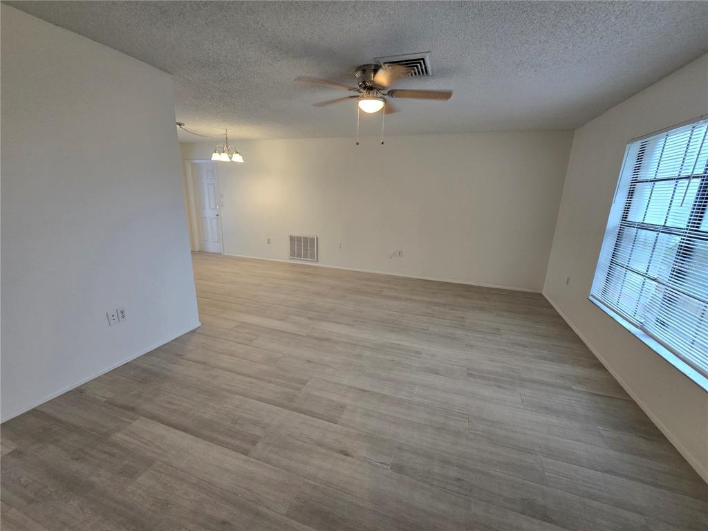 11127 Peppertree Lane Port Richey, FL 34668 - Photo 5 of 25 wooden floor in an empty room with a window