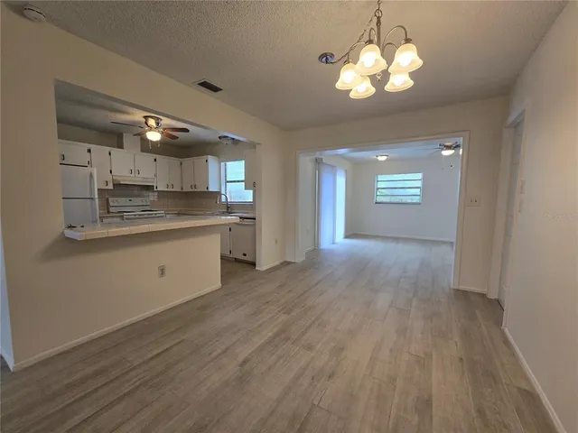 a view of a kitchen counter space a sink wooden floor and cabinets