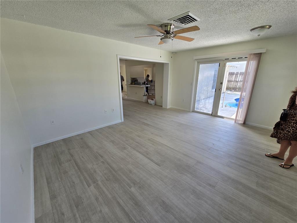11127 Peppertree Lane Port Richey, FL 34668 - Photo 9 of 25 a view of empty room with wooden floor and fan