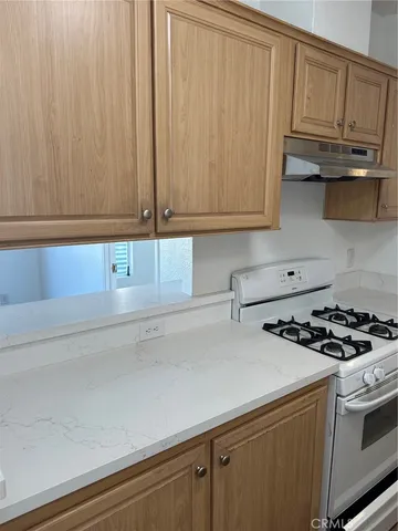 a kitchen with granite countertop cabinets and a stove top oven