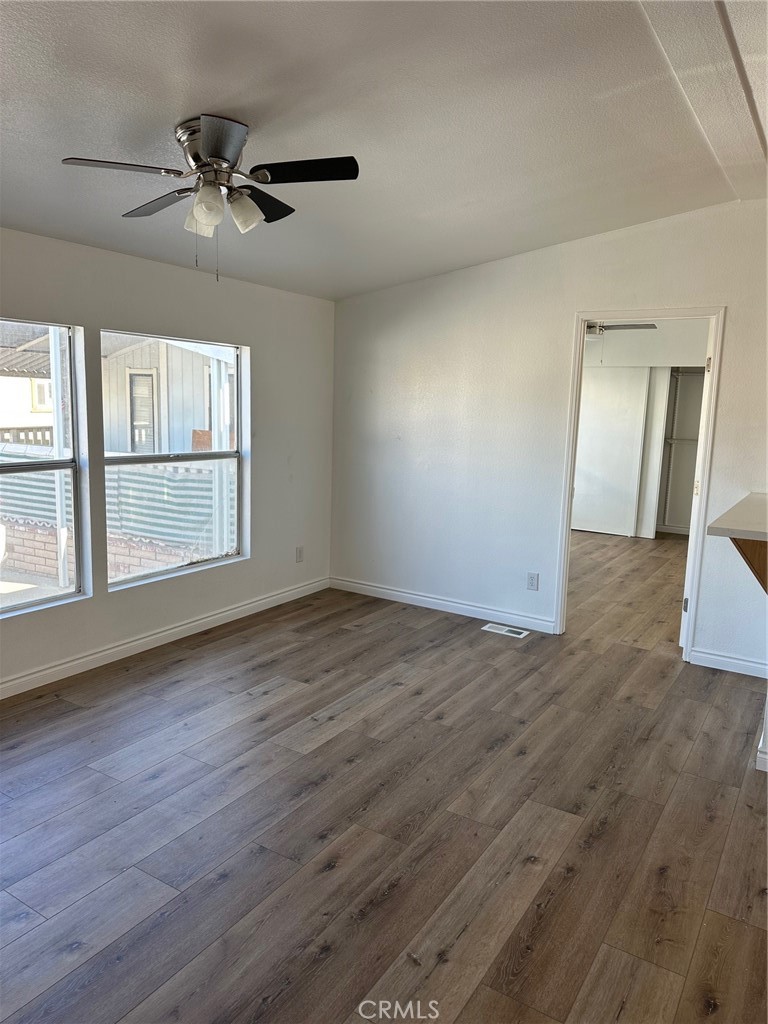 9861 Mission, Unit 14 Riverside, CA 92509 - Photo 18 of 23 an empty room with wooden floor fan and windows