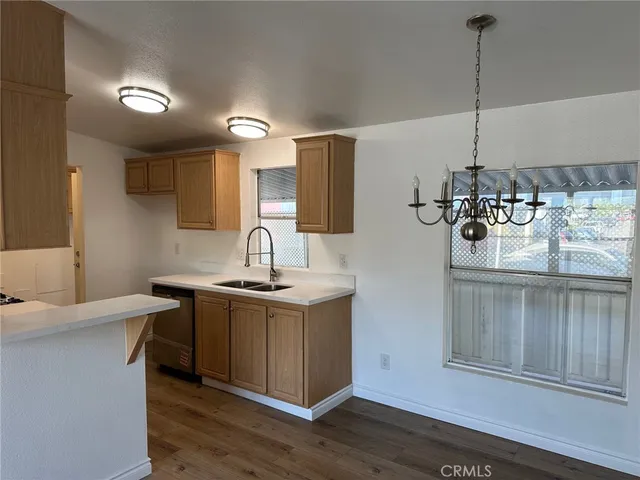 a kitchen with a sink cabinets and wooden floor