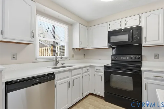 a kitchen with cabinets appliances a sink and a window