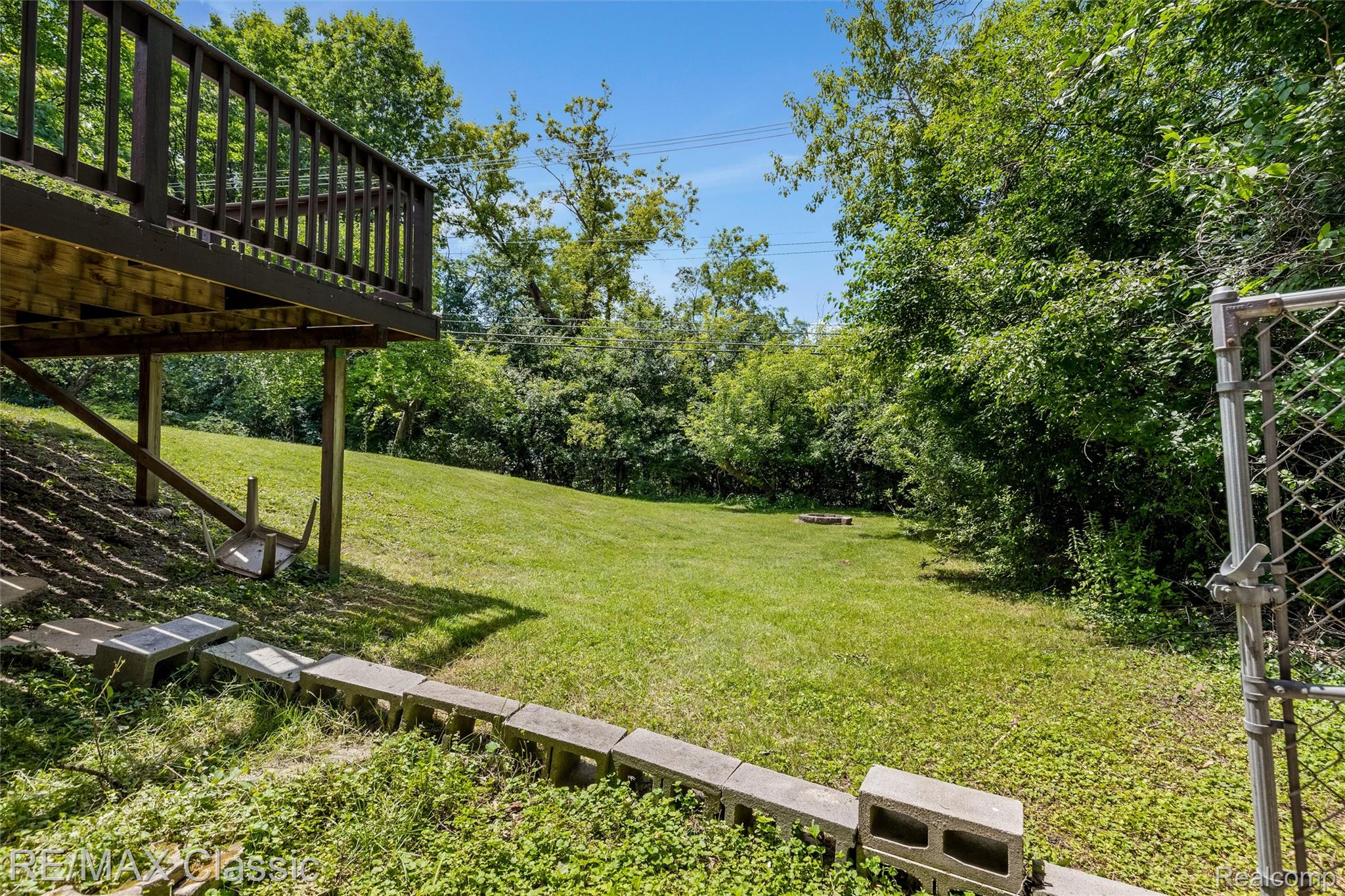 4268 Covered Bridge Road Bloomfield Hills, MI 48302 - Photo 32 of 35 Expansive green lawn with mature trees and a raised wood deck
