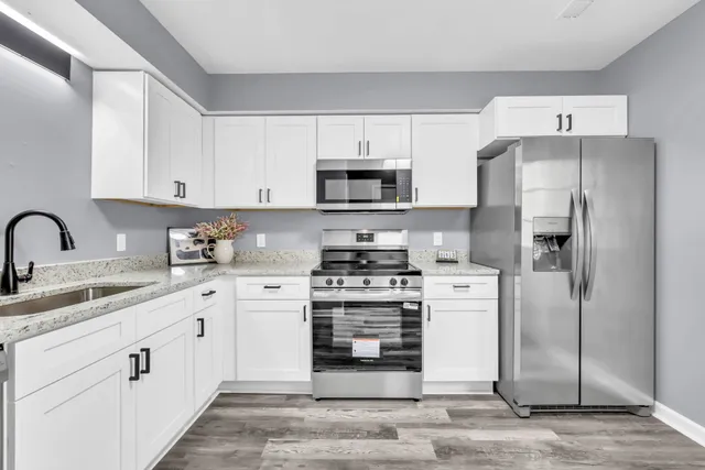 a kitchen with white cabinets and stainless steel appliances
