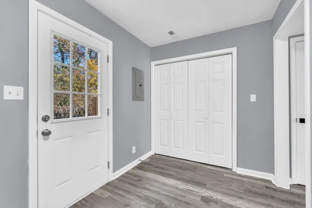 a view of an empty room with wooden floor and window