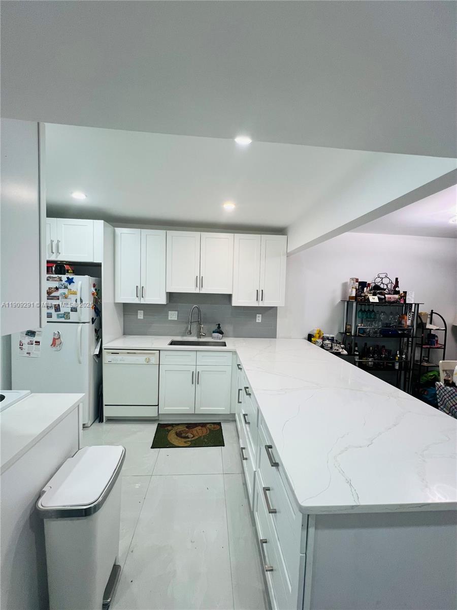 8380 Sands Point Boulevard, Unit J109 Tamarac, FL 33321 - Photo 2 of 8 a kitchen with a sink a stove and cabinets
