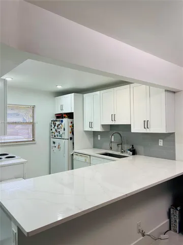 a kitchen with stainless steel appliances a refrigerator a sink and a stove