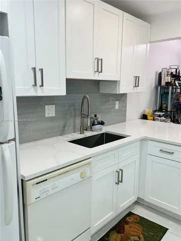 a kitchen with white cabinets and white appliances