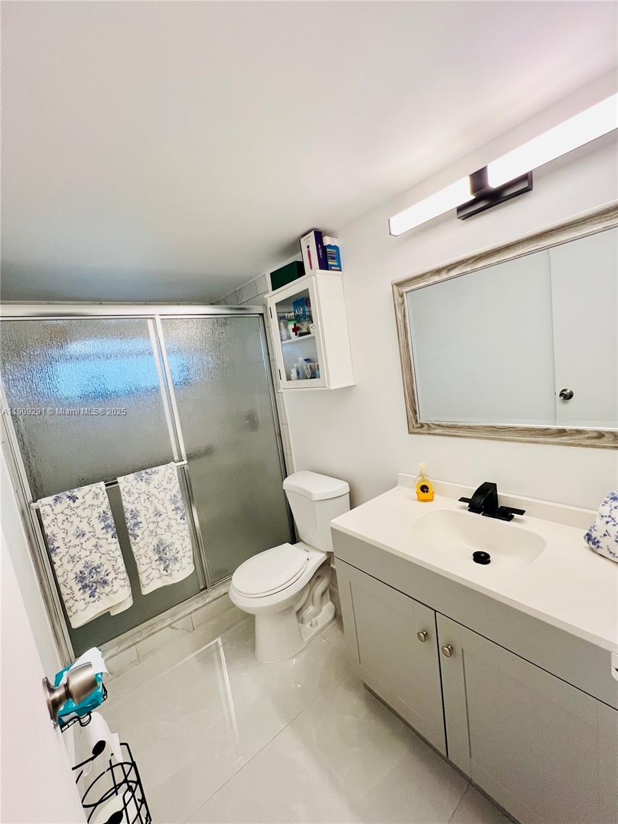 8380 Sands Point Boulevard, Unit J109 Tamarac, FL 33321 - Photo 5 of 8 a bathroom with a sink mirror vanity and toilet
