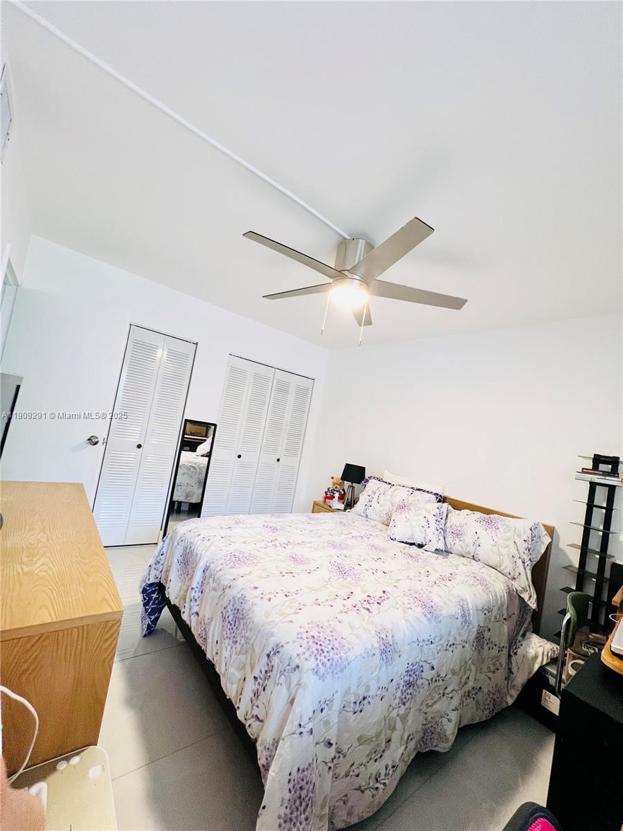 8380 Sands Point Boulevard, Unit J109 Tamarac, FL 33321 - Photo 7 of 8 a bedroom with a bed and wooden floor