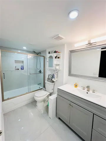 a bathroom with a double vanity sink toilet mirror and shower