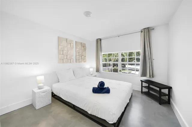 a bed sitting in a bedroom next to a window