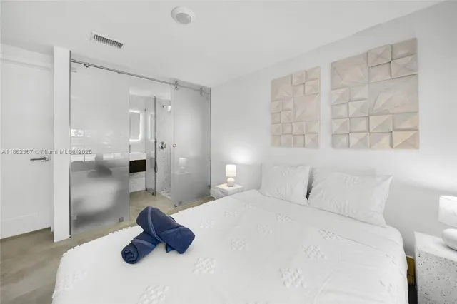 a bedroom with a bed and a large mirror