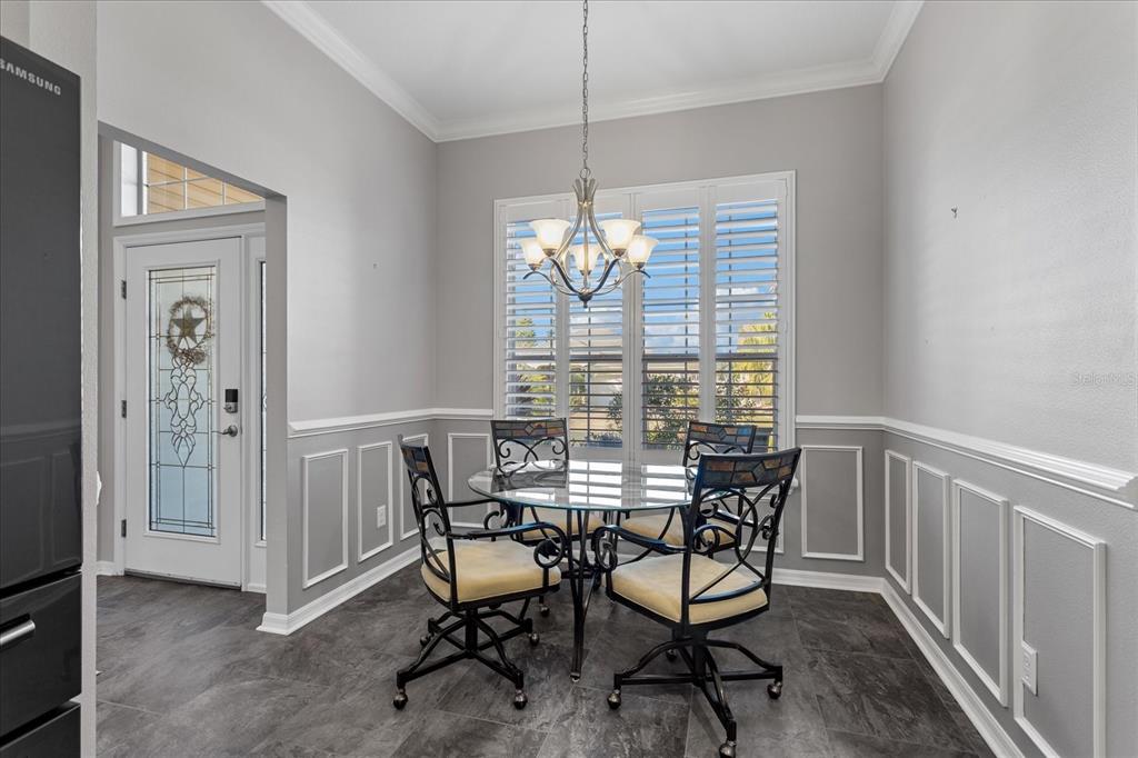 566 Allenwood Loop The Villages, FL 32162 - Photo 15 of 32 a view of a dining room with furniture and chandelier