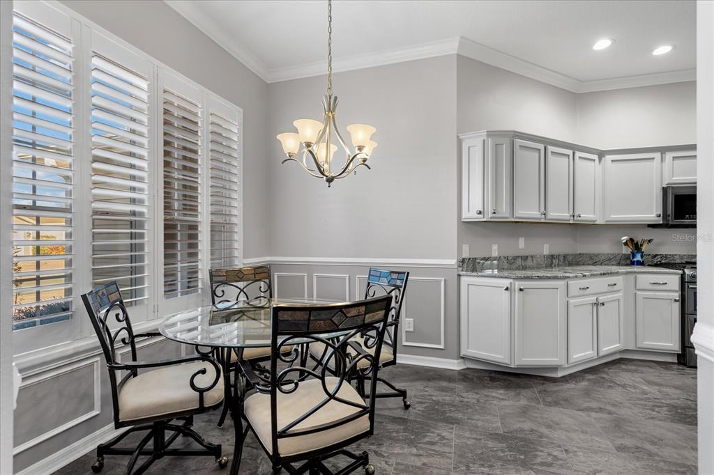 566 Allenwood Loop The Villages, FL 32162 - Photo 16 of 32 a view of a dining room with furniture and chandelier