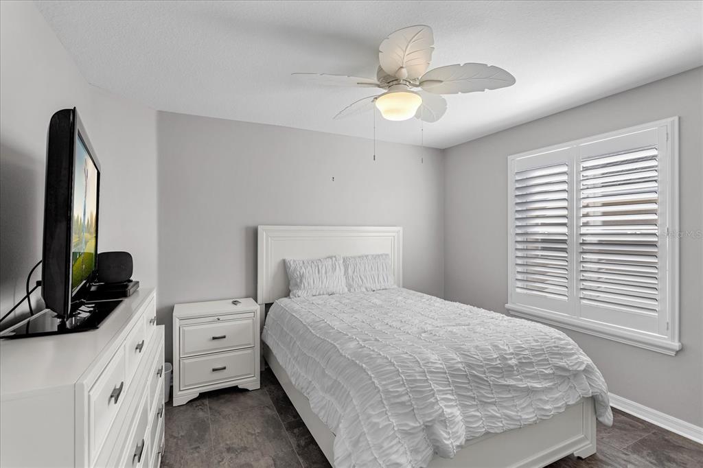 566 Allenwood Loop The Villages, FL 32162 - Photo 26 of 32 a bedroom with a bed and a flat tv screen on dresser