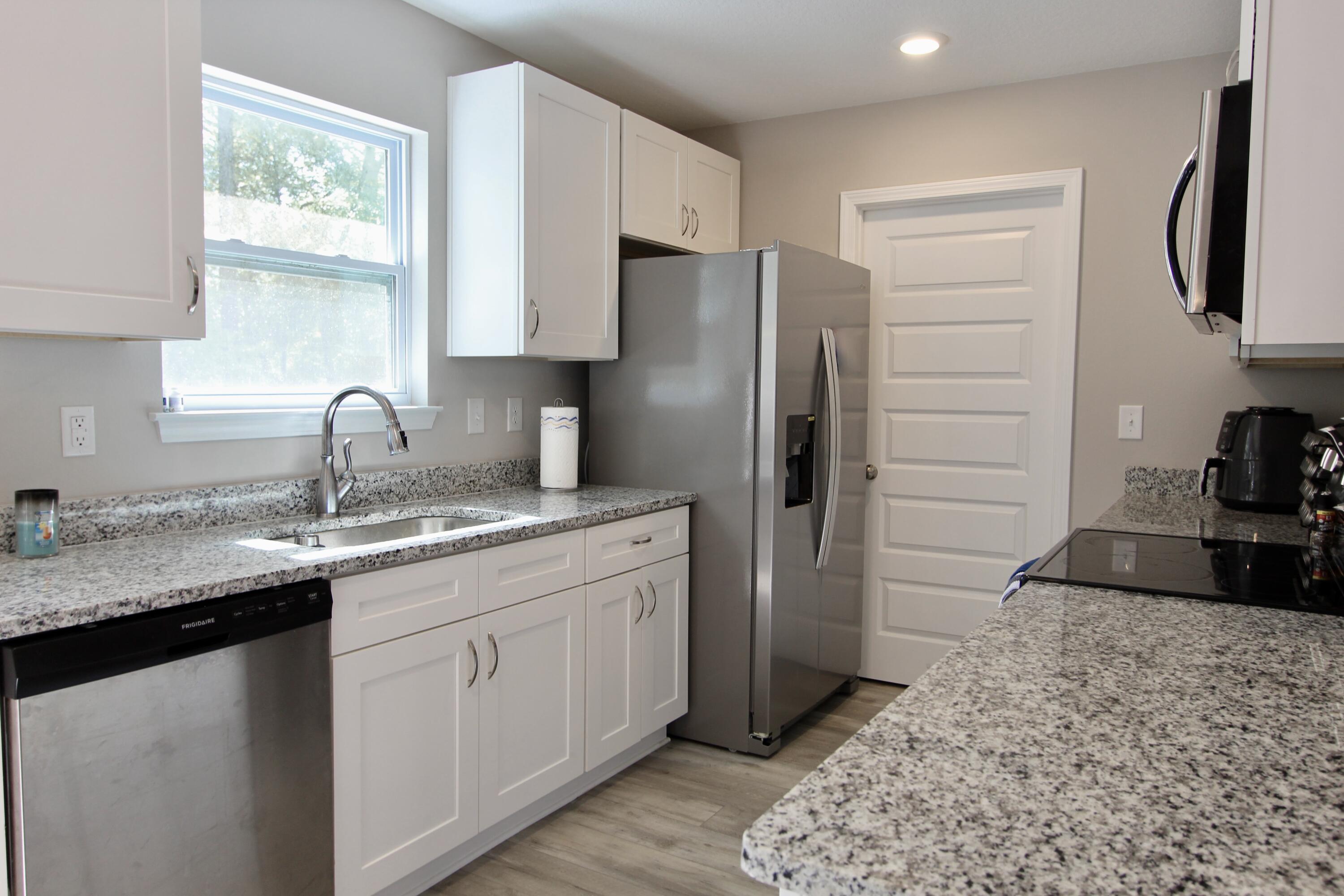 102 Windsor Drive Crestview, FL 32539 - Photo 11 of 26 a kitchen with stainless steel appliances granite countertop a sink stove and refrigerator