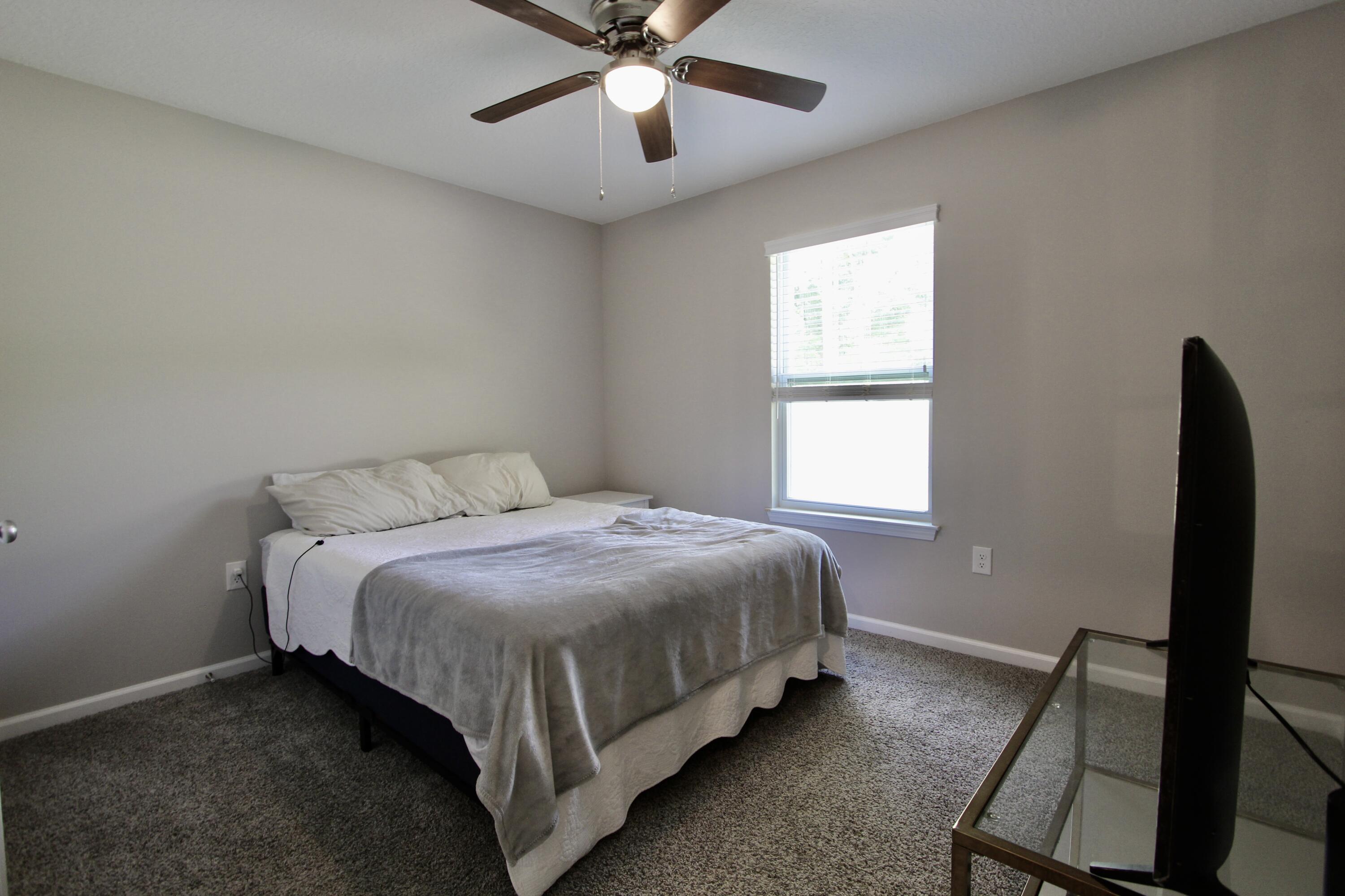102 Windsor Drive Crestview, FL 32539 - Photo 15 of 26 a bed sitting in a bedroom next to a window