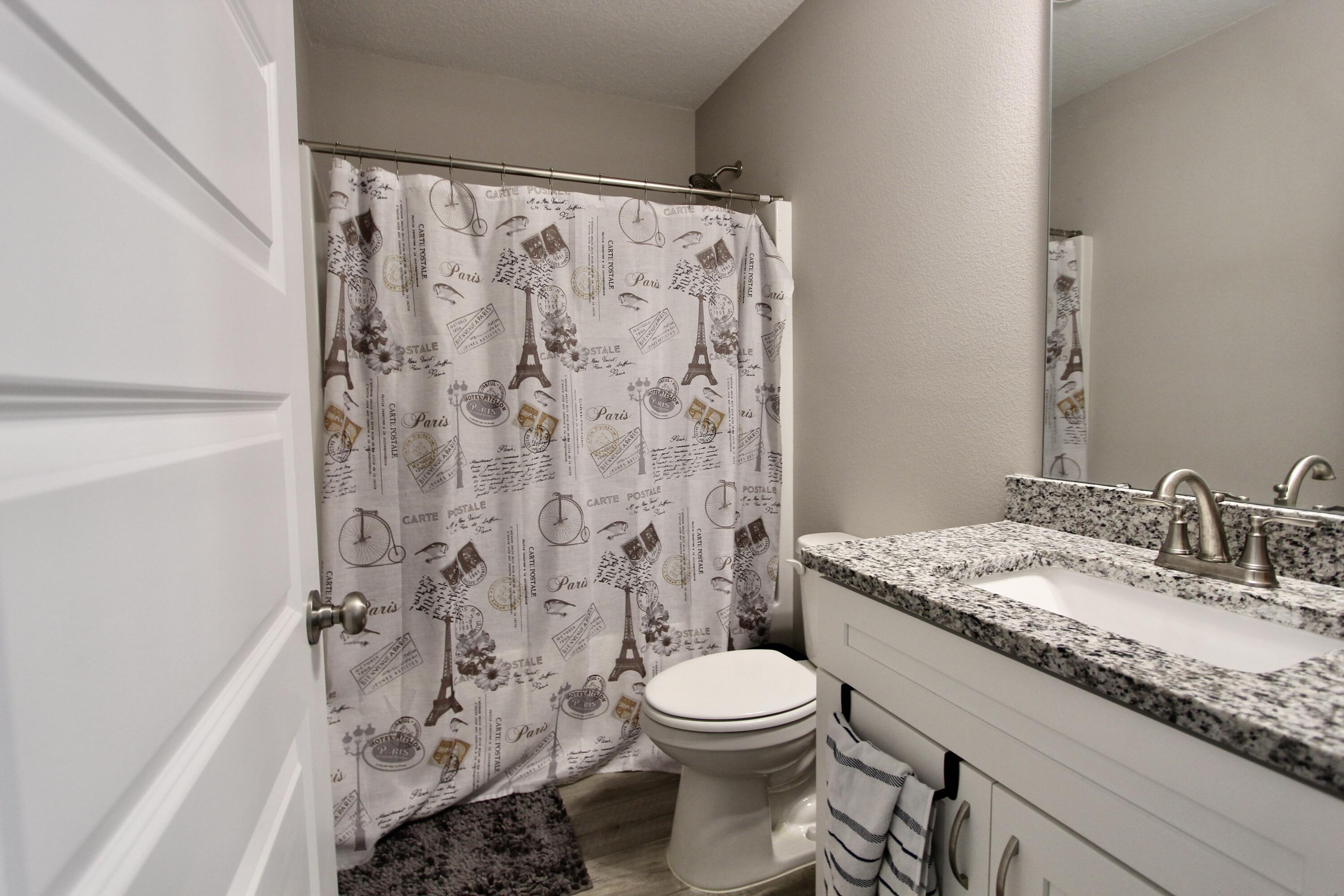 102 Windsor Drive Crestview, FL 32539 - Photo 16 of 26 a bathroom with a granite countertop toilet a sink and a shower