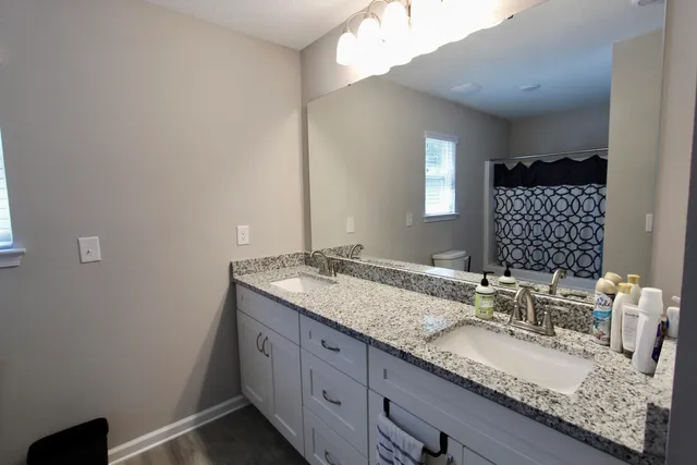 a bathroom with a granite countertop sink and a mirror