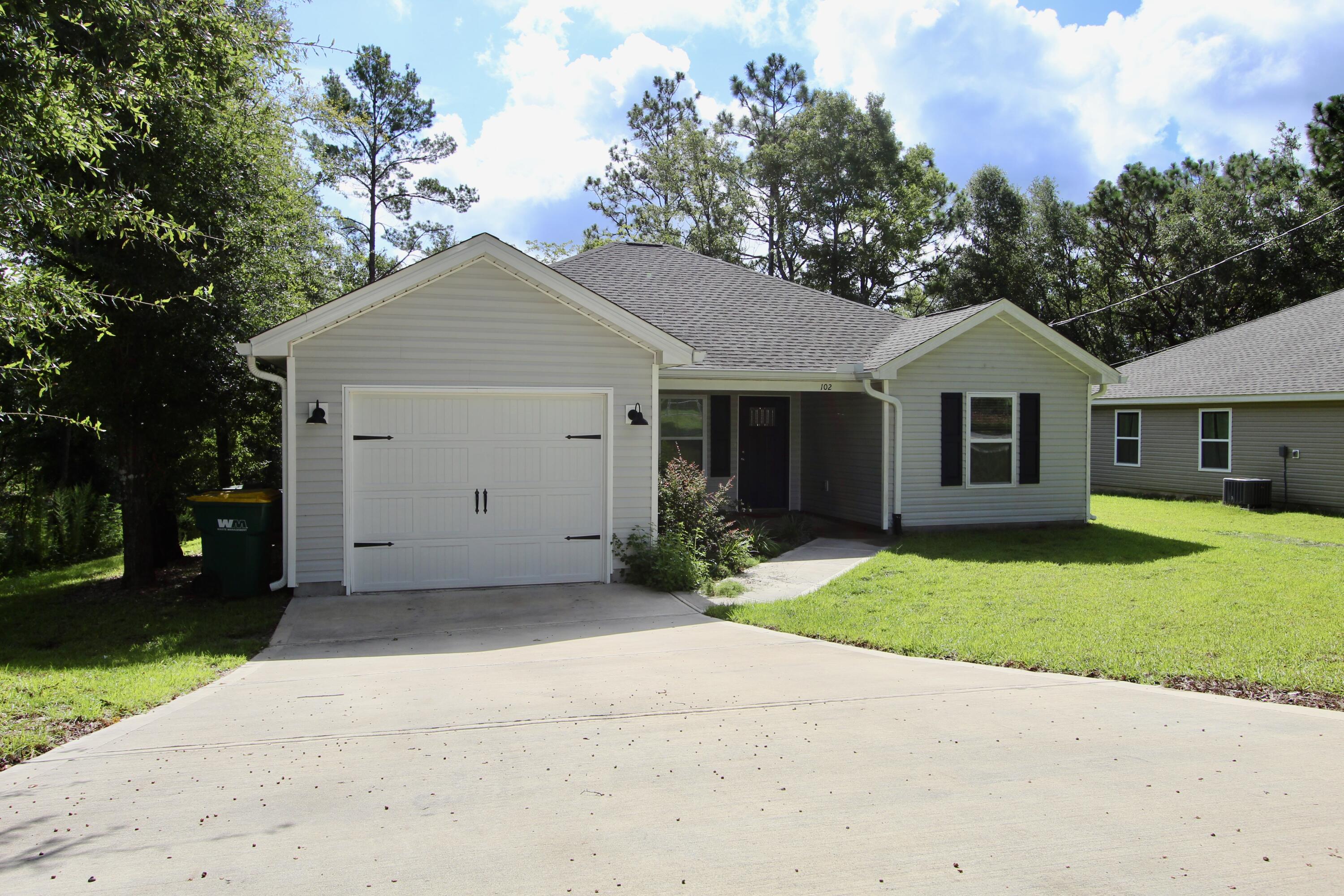 102 Windsor Drive Crestview, FL 32539 - Photo 2 of 26 a front view of a house with a yard and garage