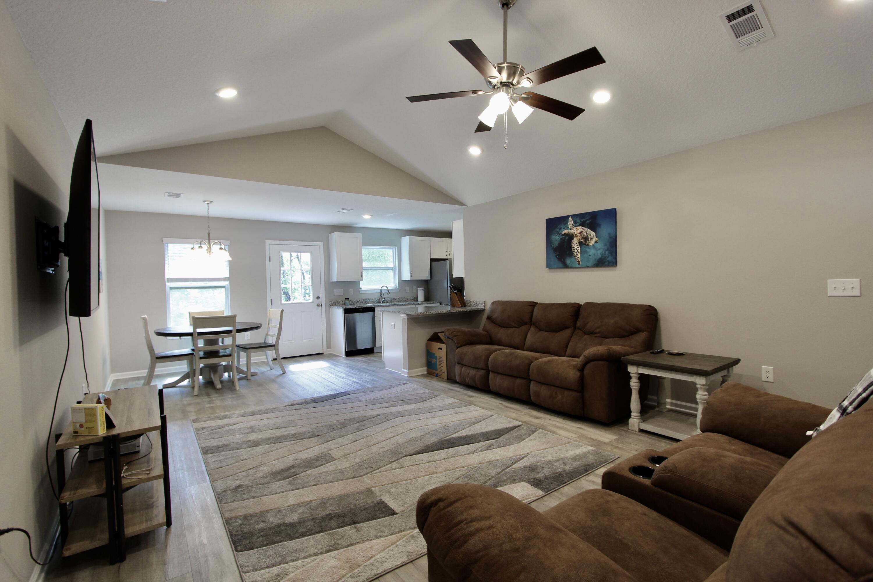 102 Windsor Drive Crestview, FL 32539 - Photo 5 of 26 a living room with furniture and a flat screen tv with kitchen view