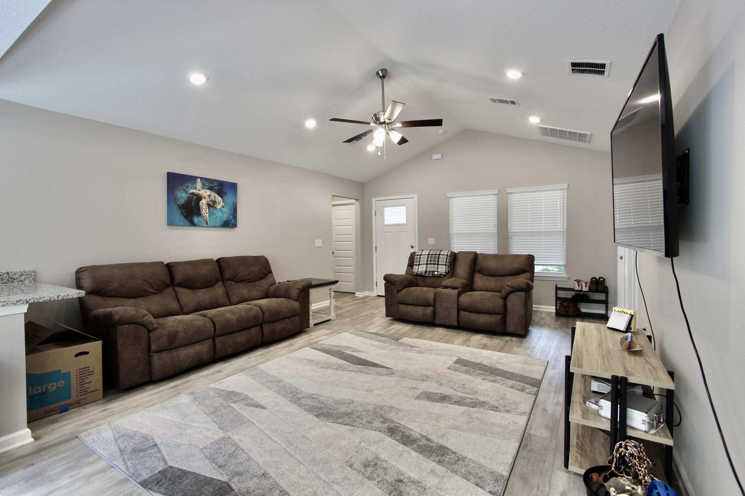 102 Windsor Drive Crestview, FL 32539 - Photo 7 of 26 a living room with furniture a flat screen tv and a ceiling fan