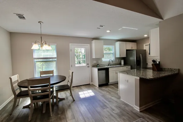 a kitchen with a dining table chairs stove and cabinets