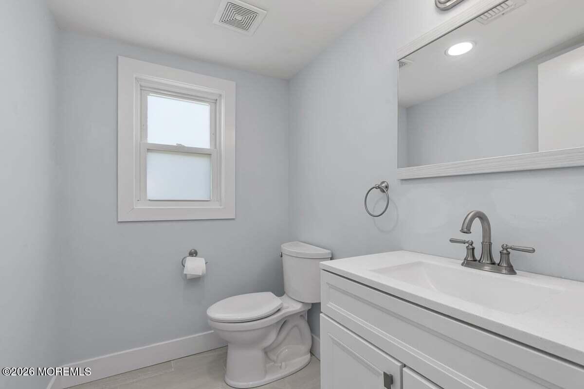 25 Howland Place Long Branch, NJ 07740 - Photo 11 of 13 a bathroom with a toilet sink vanity and mirror