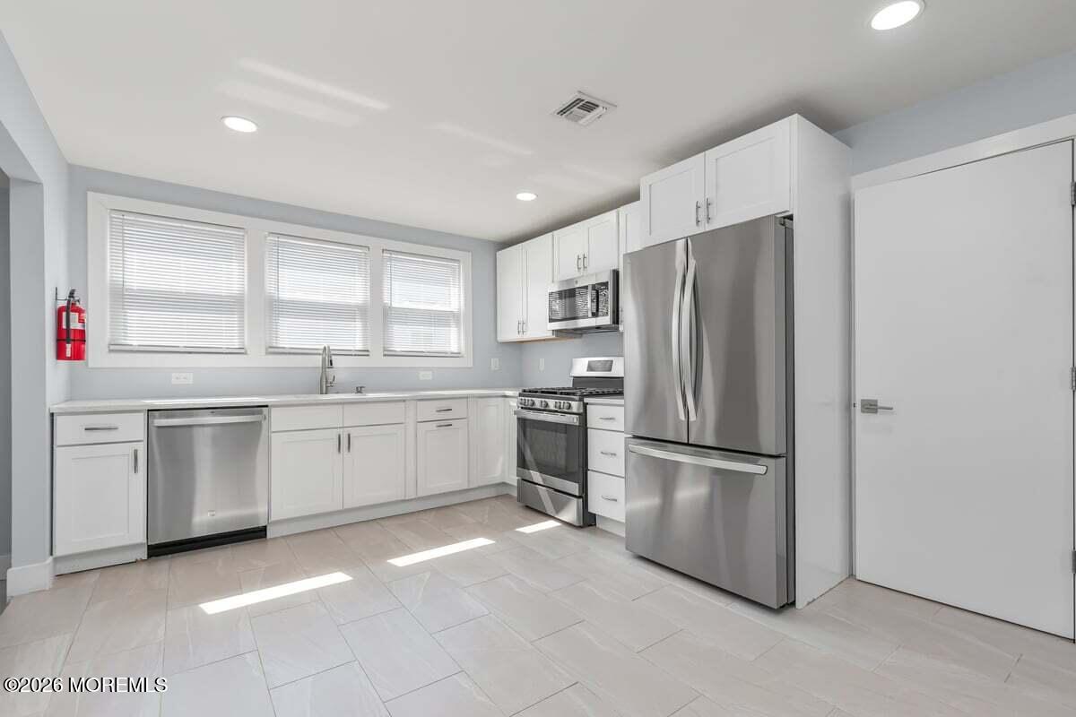 25 Howland Place Long Branch, NJ 07740 - Photo 2 of 13 a kitchen with white cabinets and stainless steel appliances