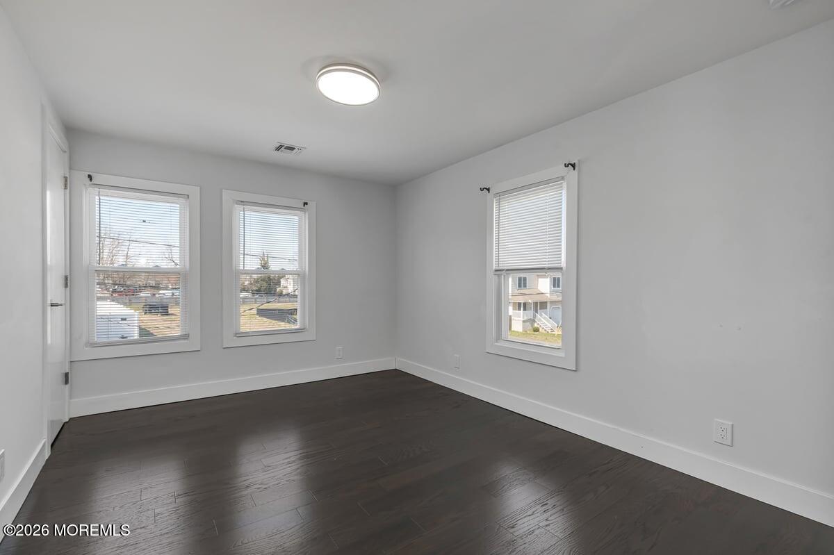 25 Howland Place Long Branch, NJ 07740 - Photo 8 of 13 an empty room with wooden floor and windows