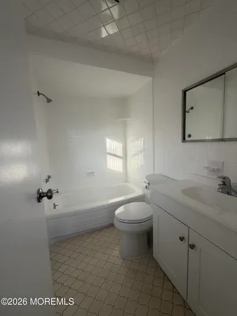 a bathroom with a granite countertop toilet a sink a mirror and vanity