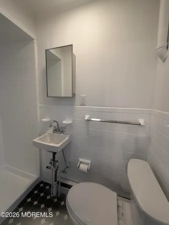 a bathroom with a toilet a sink and a mirror
