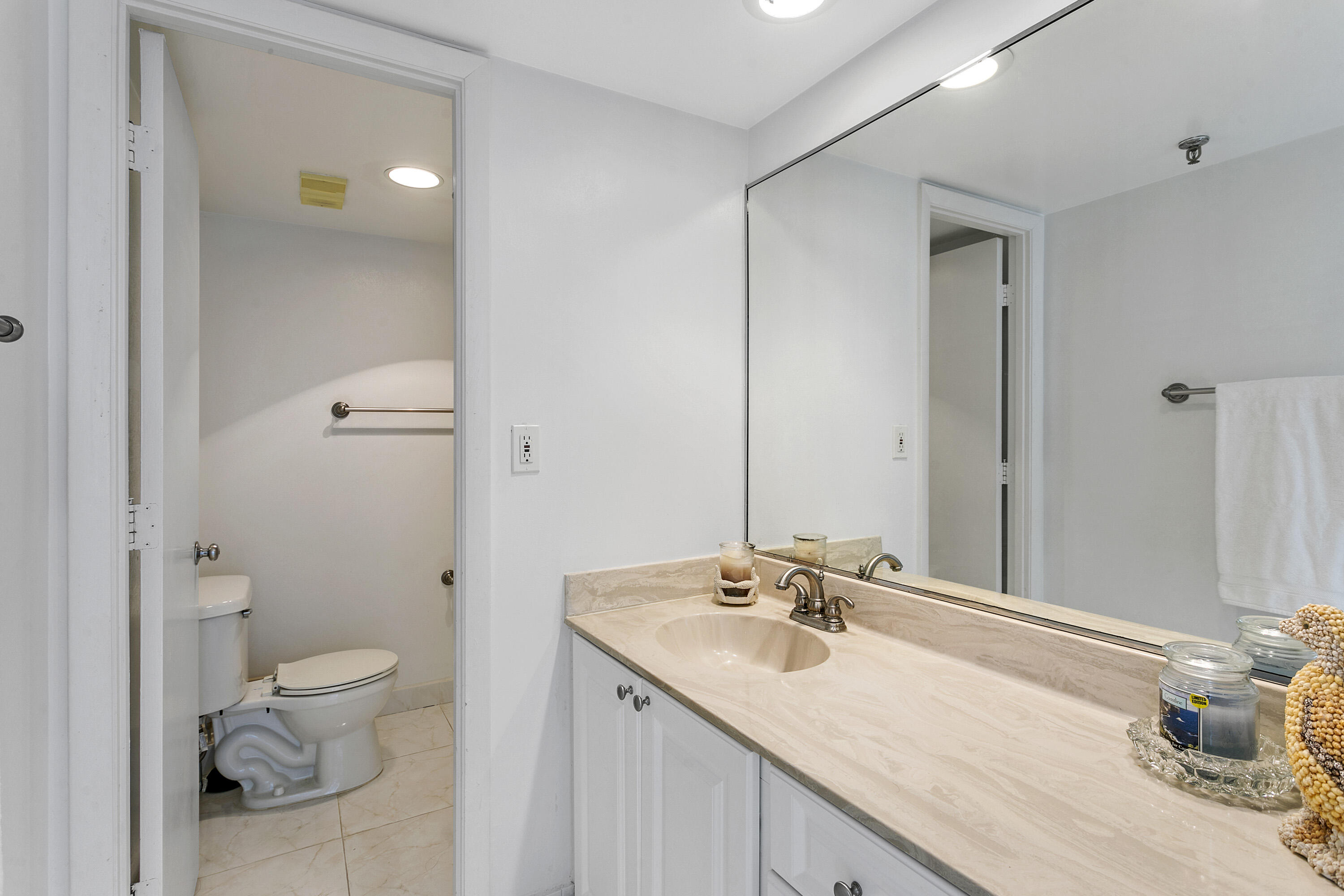 100 Ocean Trail Way, Unit 501 Jupiter, FL 33477 - Photo 19 of 30 a bathroom with a granite countertop sink a toilet and a large mirror