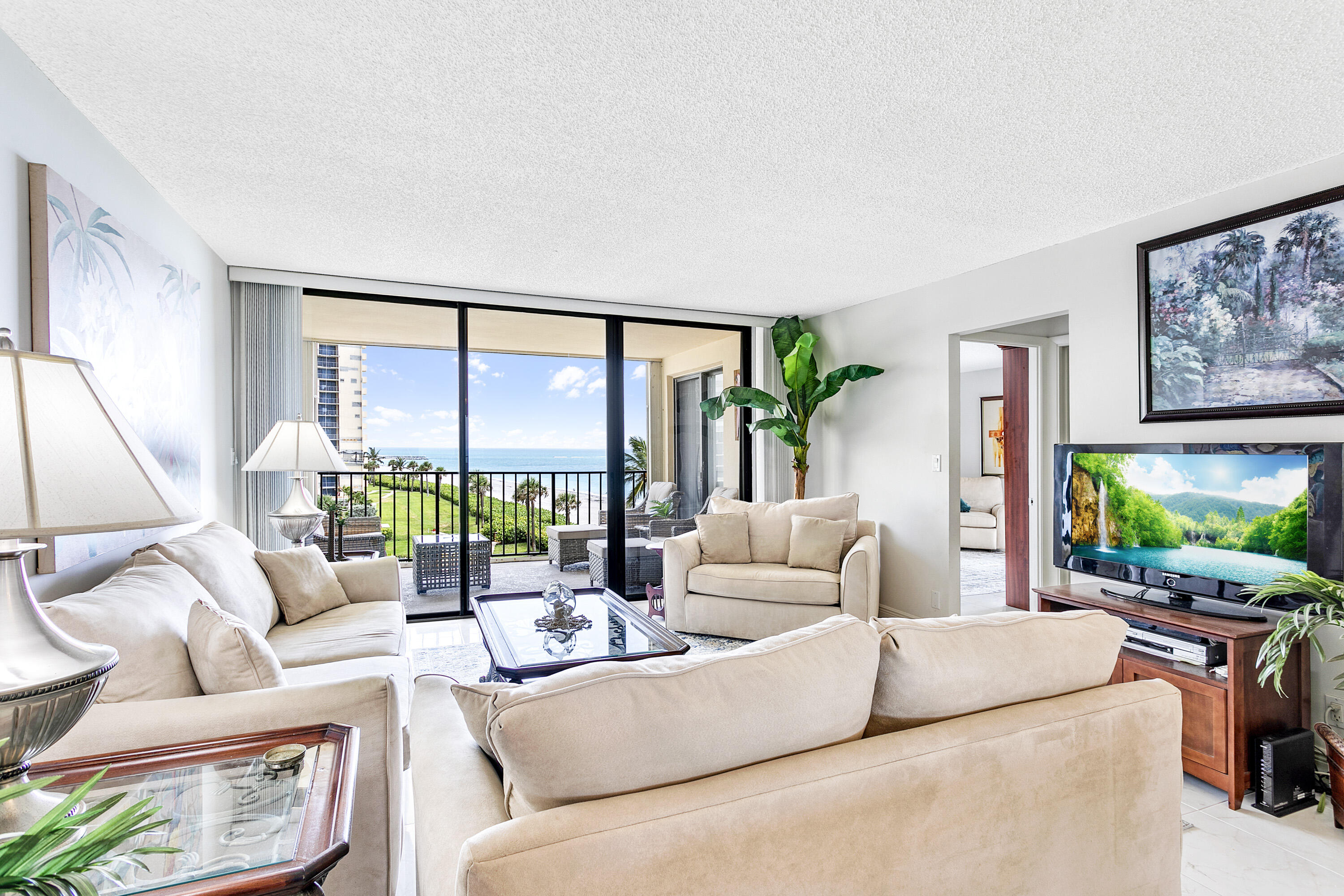 100 Ocean Trail Way, Unit 501 Jupiter, FL 33477 - Photo 5 of 30 a living room with furniture a flat screen tv and a large window