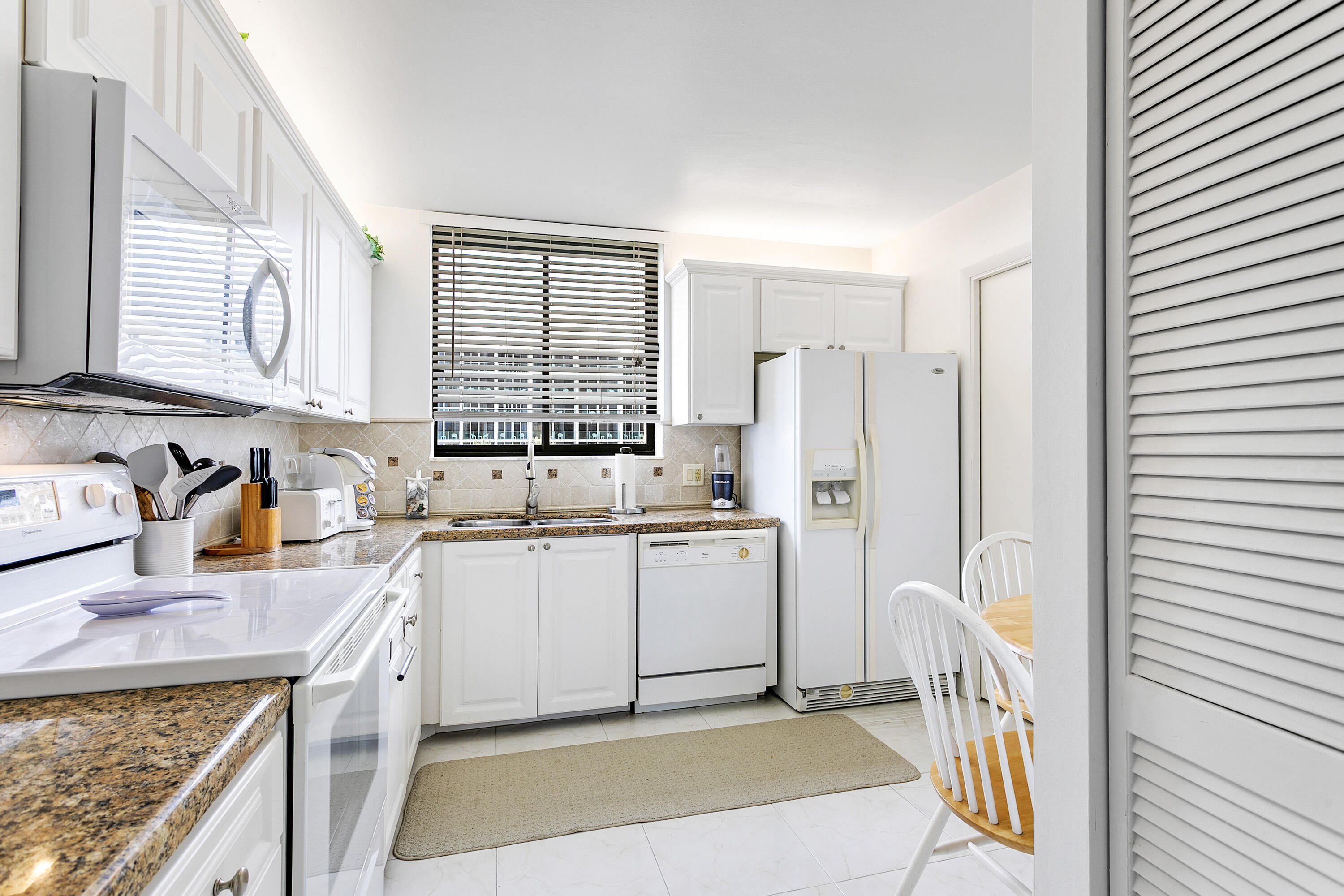 100 Ocean Trail Way, Unit 501 Jupiter, FL 33477 - Photo 8 of 30 a kitchen with a sink stove and refrigerator