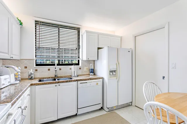 a kitchen with a sink appliances cabinets and a window