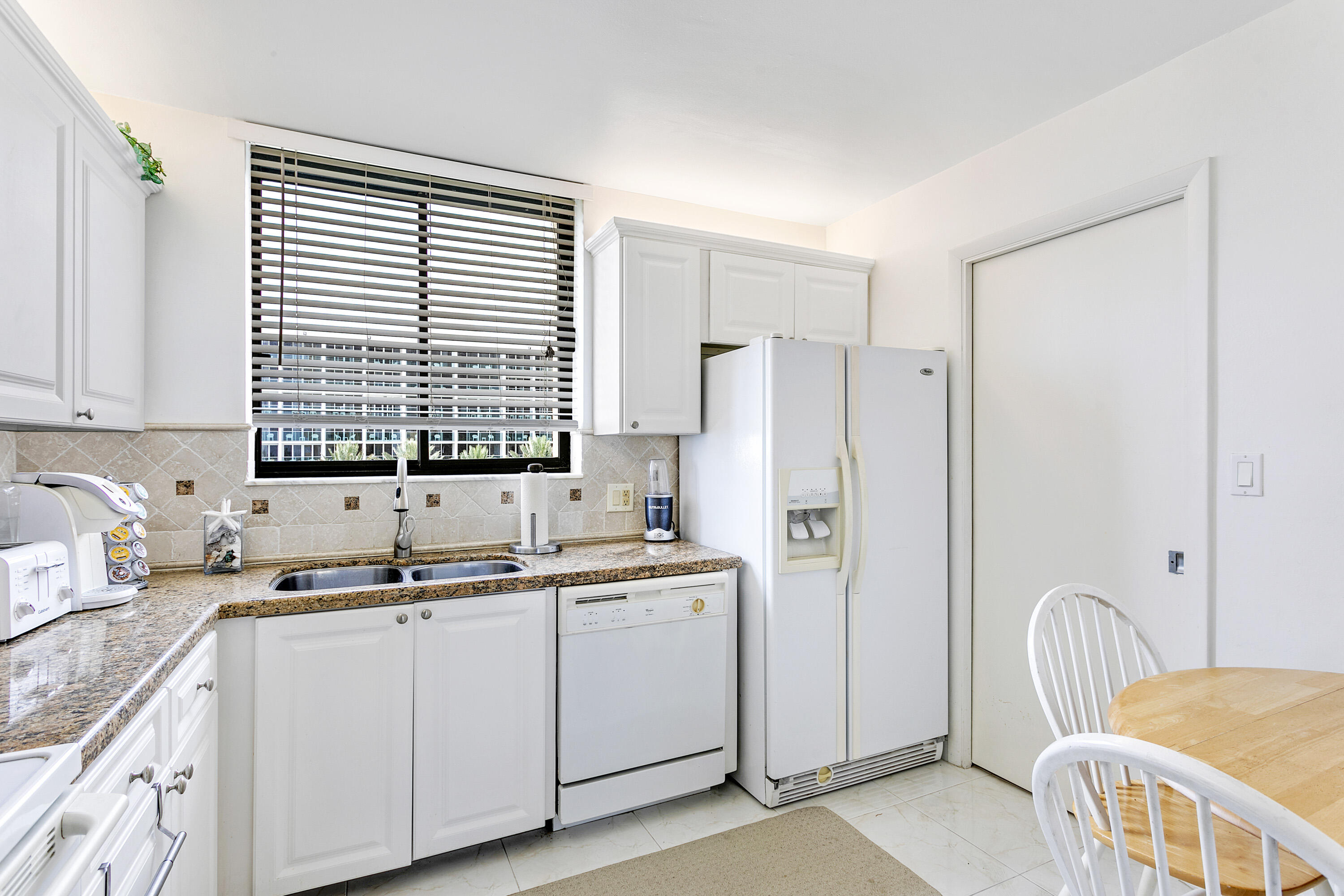 100 Ocean Trail Way, Unit 501 Jupiter, FL 33477 - Photo 10 of 30 a kitchen with a sink appliances cabinets and a window