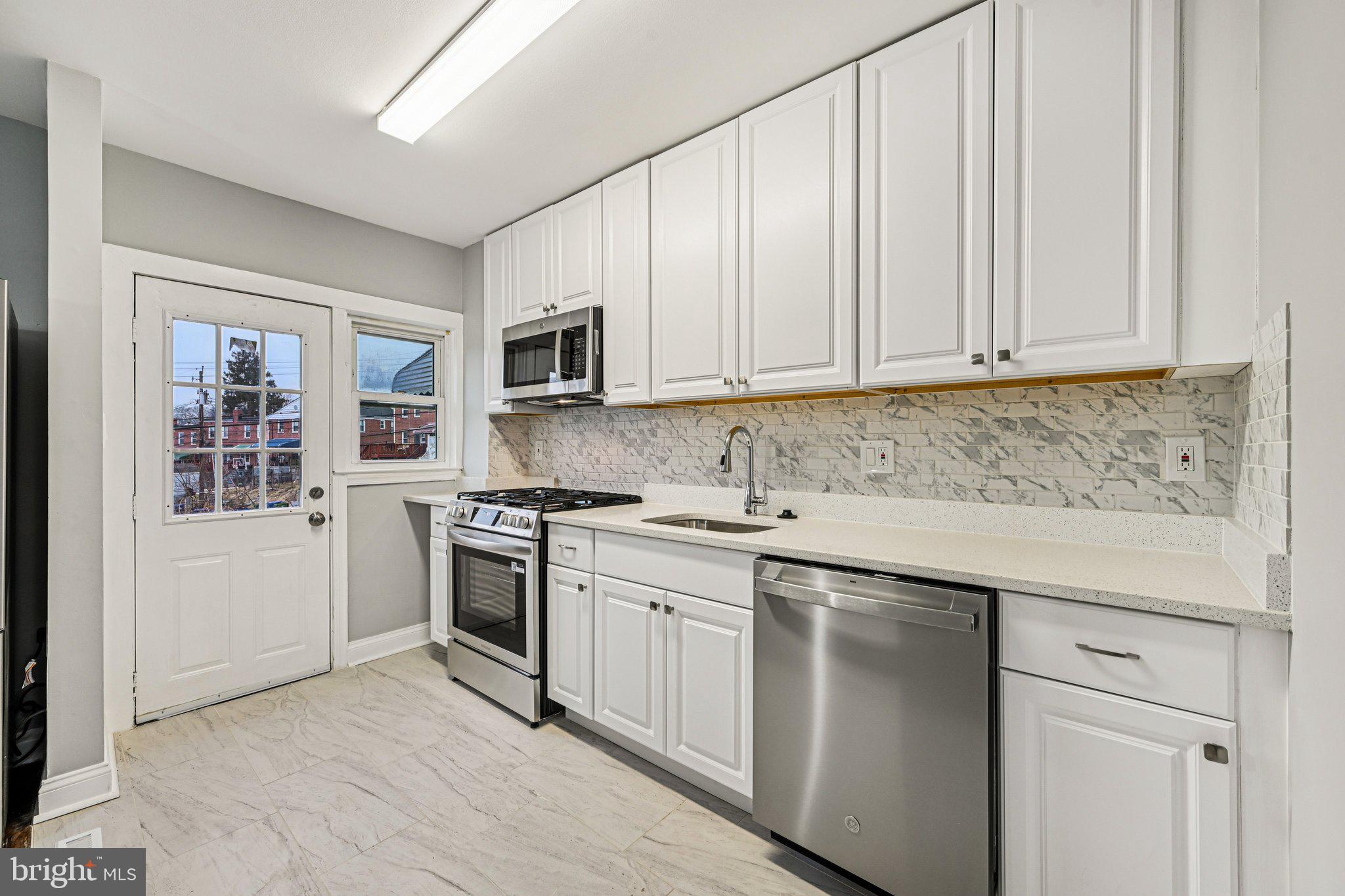 38 Upmanor Road Baltimore, MD 21229 - Photo 12 of 35 a kitchen with stainless steel appliances granite countertop a stove a sink and a microwave