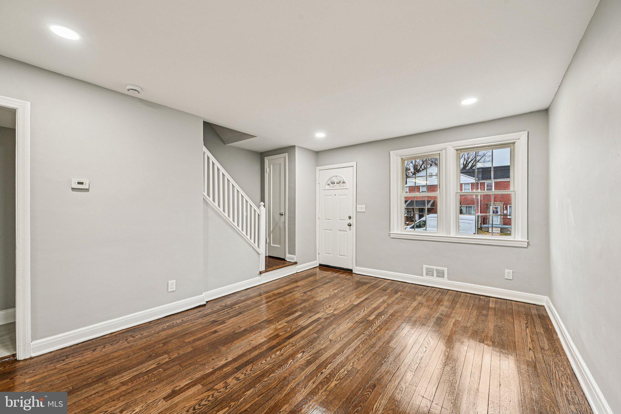 38 Upmanor Road Baltimore, MD 21229 - Photo 4 of 35 a view of an empty room with wooden floor and a window