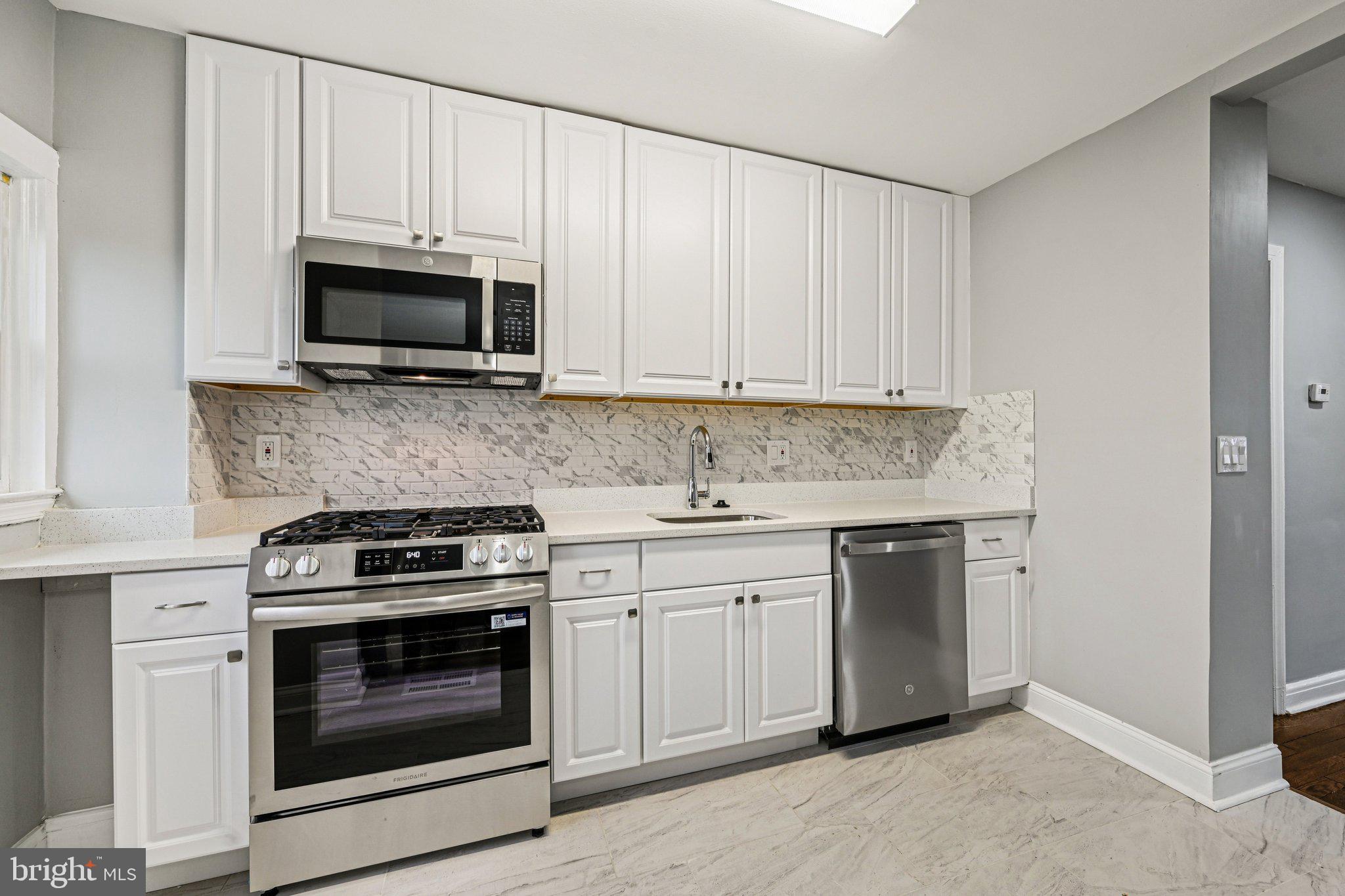 38 Upmanor Road Baltimore, MD 21229 - Photo 10 of 35 a kitchen with white cabinets and stainless steel appliances