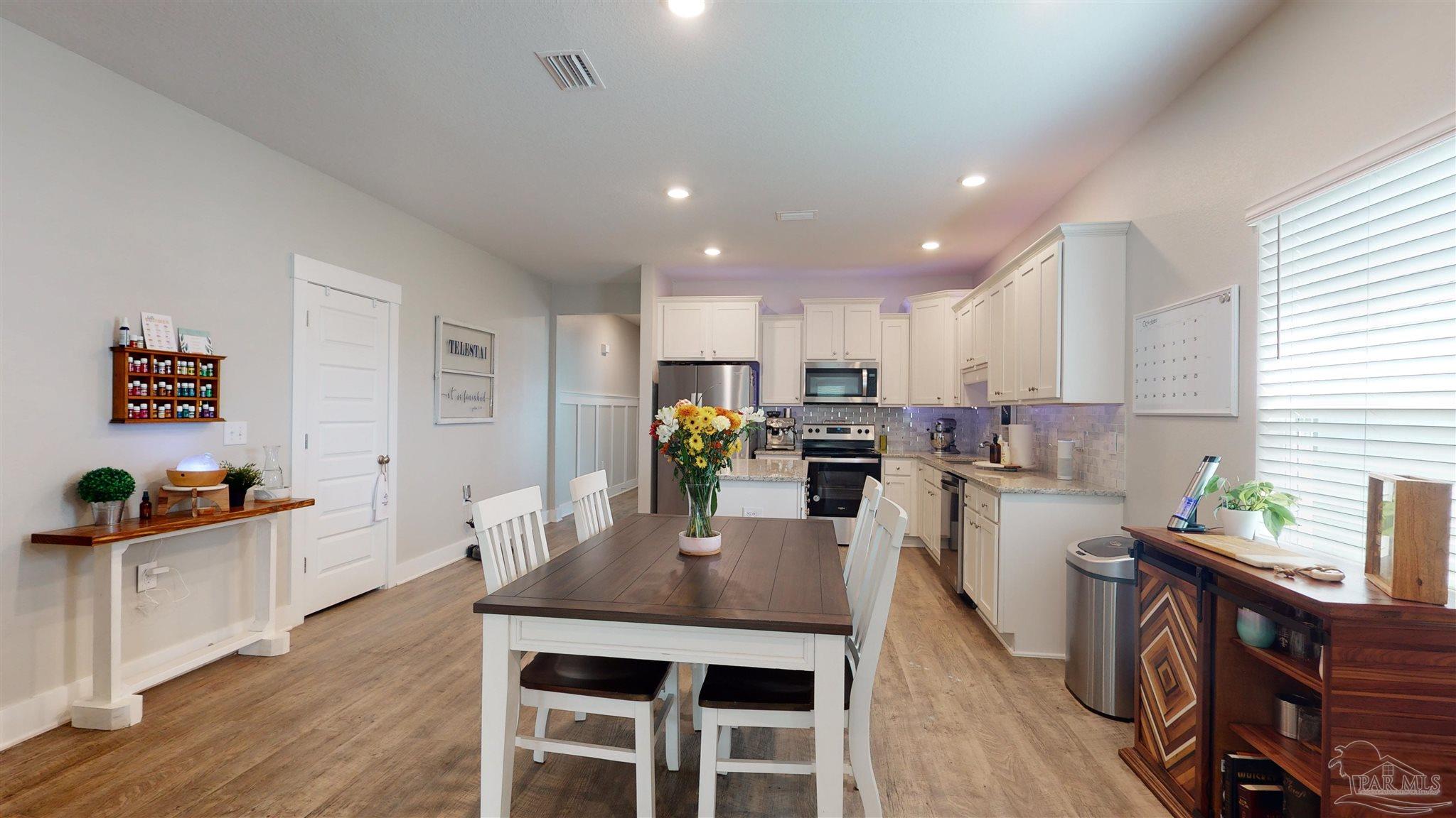 5789 Conley Court Milton, FL 32571 - Photo 15 of 50 a kitchen with a table chairs refrigerator and microwave