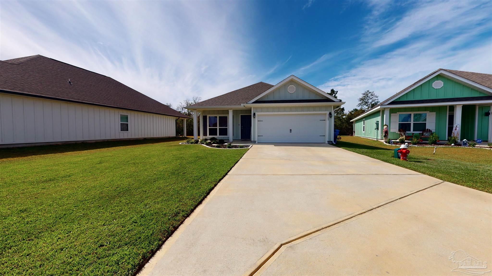 5789 Conley Court Milton, FL 32571 - Photo 3 of 50 a front view of a house with a yard and garage
