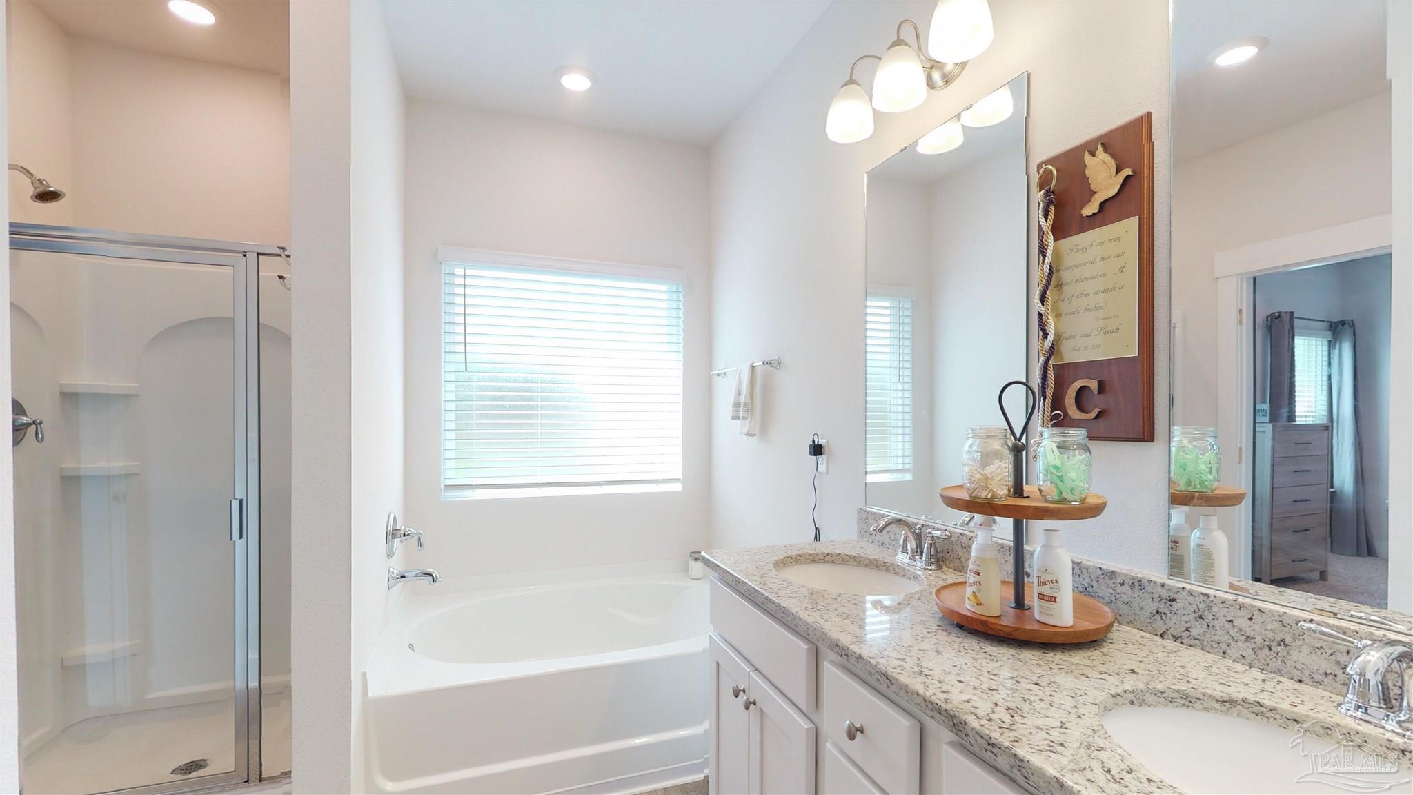 5789 Conley Court Milton, FL 32571 - Photo 30 of 50 a bathroom with a granite countertop sink a large mirror and shower