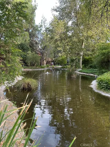 a view of a lake with a yard and large trees