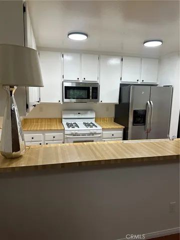 a kitchen with stainless steel appliances a stove refrigerator sink and a stove